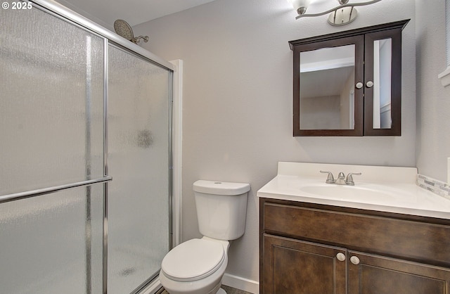 bathroom with a shower with door, vanity, and toilet