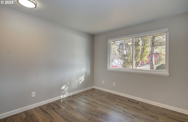 unfurnished room featuring dark wood-type flooring