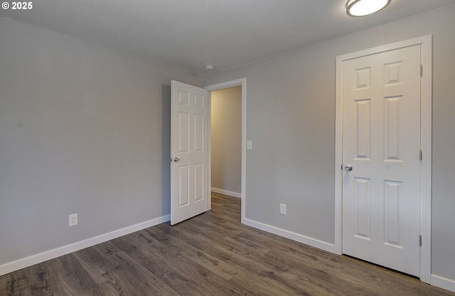 unfurnished bedroom featuring dark hardwood / wood-style flooring