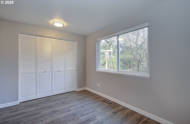 unfurnished bedroom with hardwood / wood-style flooring and a closet