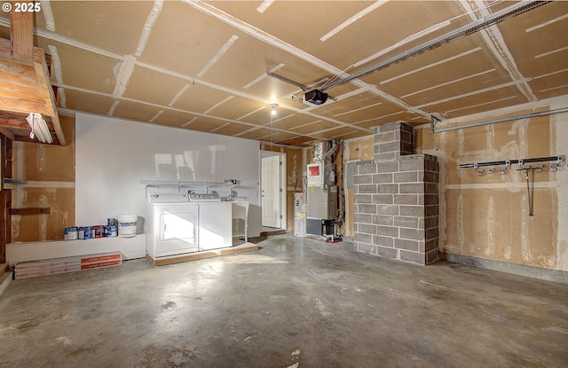 garage featuring a garage door opener, heating unit, and washer and clothes dryer