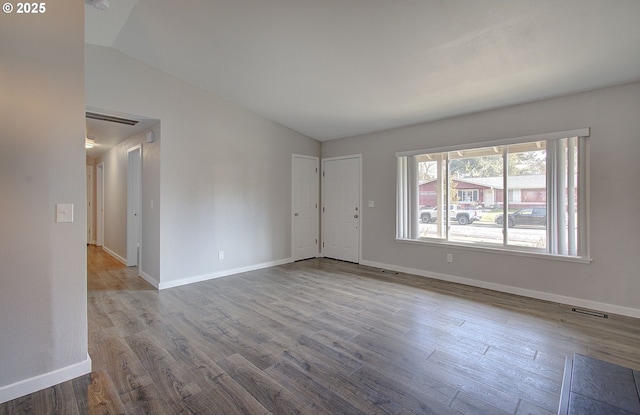 spare room with vaulted ceiling and light hardwood / wood-style flooring