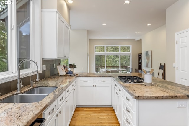 1916 NW Runnymeade Ct, Portland, OR 97229 - kitchen with a sink, stainless steel gas cooktop, recessed lighting, a peninsula, and white cabinets