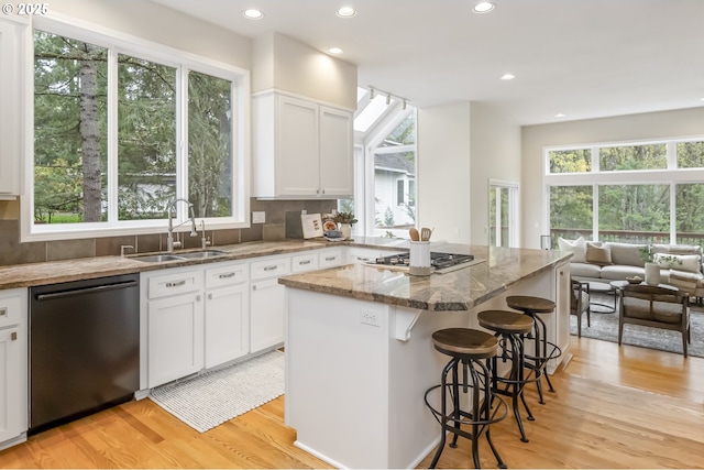 1916 NW Runnymeade Ct, Portland, OR 97229 - kitchen featuring dishwashing machine, a sink, stainless steel gas stovetop, stone counters, and light wood-type flooring