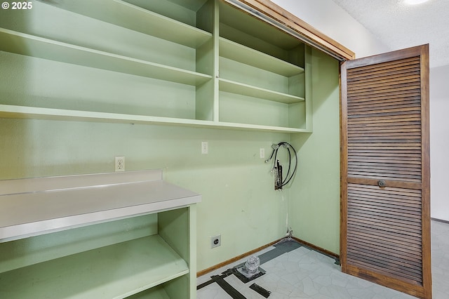 laundry area featuring electric dryer hookup and baseboards