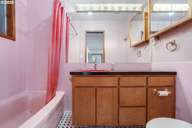 bathroom featuring shower / bath combo, toilet, vanity, and tile walls