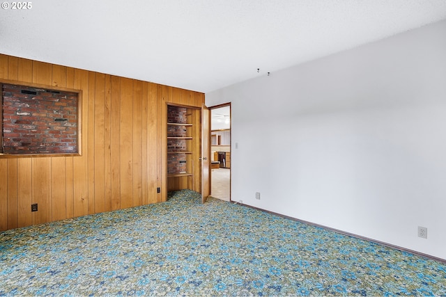 empty room with carpet flooring and wooden walls