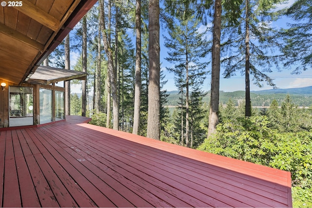 wooden deck with a sunroom and a mountain view
