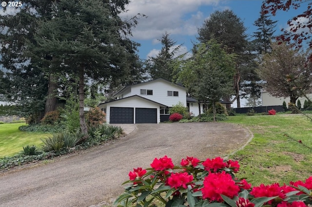 view of front of home with fence, aphalt driveway, a front lawn, and a garage