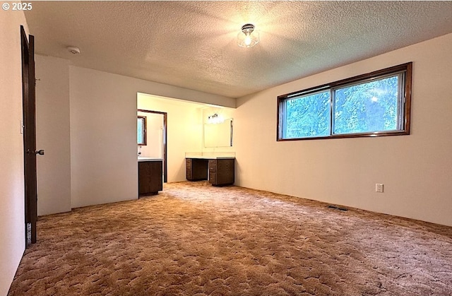 unfurnished bedroom featuring carpet floors, a textured ceiling, and visible vents
