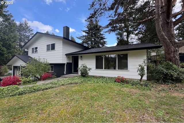 tri-level home with a chimney and a front yard