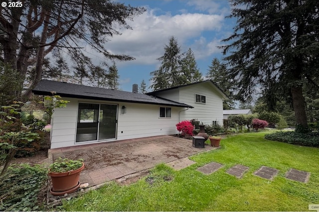 back of house featuring a lawn and a patio