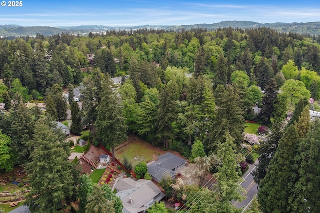 birds eye view of property featuring a wooded view and a mountain view
