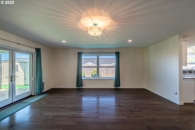 spare room with dark wood-type flooring, recessed lighting, and french doors