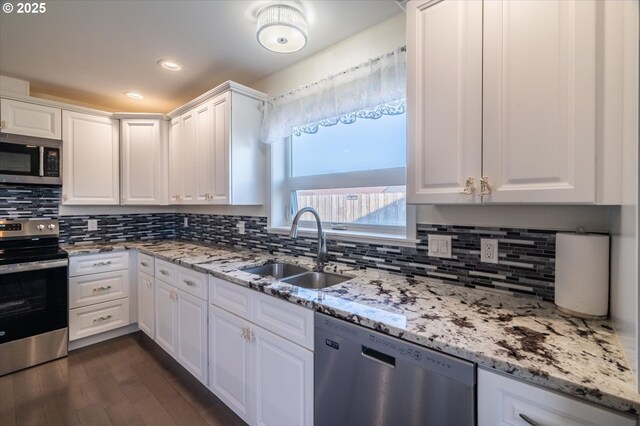 kitchen featuring tasteful backsplash, appliances with stainless steel finishes, white cabinetry, and a sink