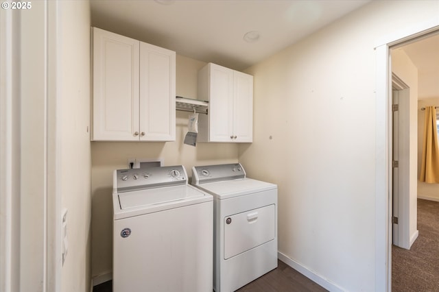 clothes washing area with baseboards, washer and dryer, and cabinet space