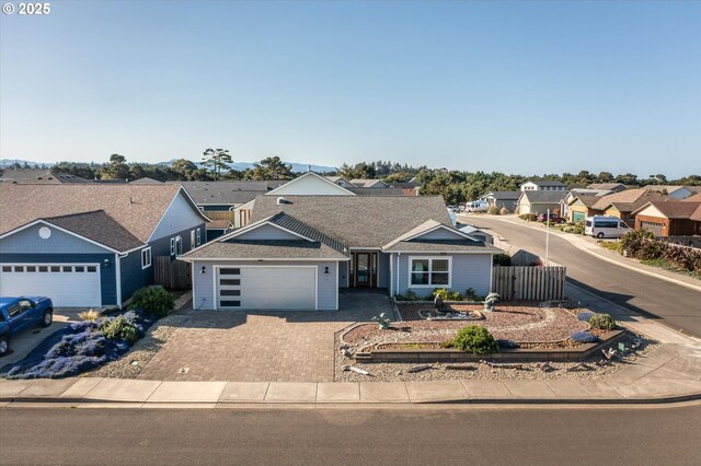 ranch-style home featuring a residential view, driveway, fence, a garage, and a shingled roof