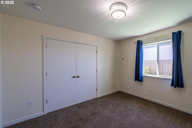 unfurnished bedroom featuring carpet floors, a closet, and baseboards