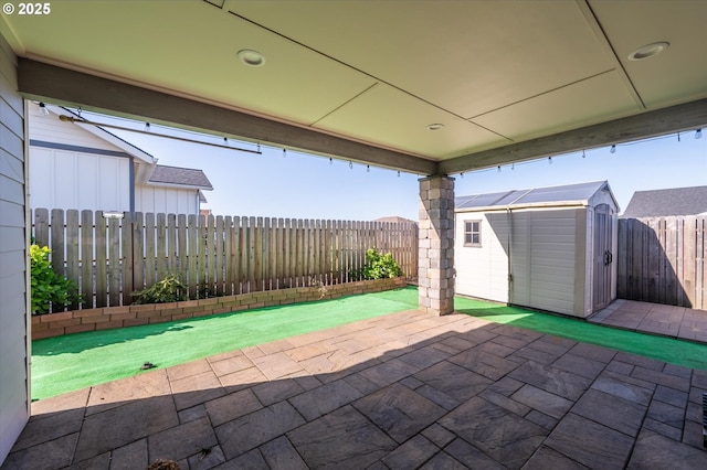 view of patio / terrace featuring a storage unit, an outbuilding, and a fenced backyard