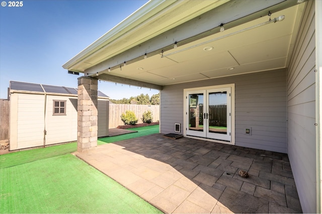 view of patio / terrace featuring a fenced backyard, an outbuilding, french doors, and a shed