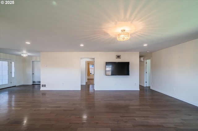 unfurnished living room with baseboards, a chandelier, dark wood-type flooring, and recessed lighting