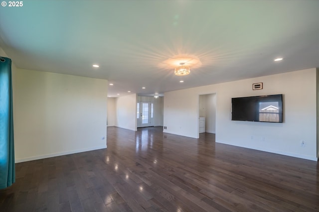 unfurnished living room featuring baseboards, recessed lighting, and dark wood finished floors