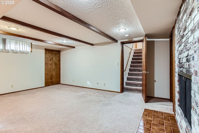 below grade area featuring a textured ceiling, carpet floors, a fireplace, baseboards, and stairs