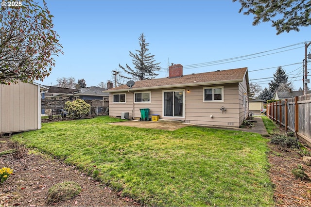 back of property featuring an outbuilding, a patio, a fenced backyard, a lawn, and a chimney