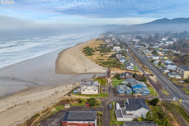 birds eye view of property with a water and mountain view and a view of the beach