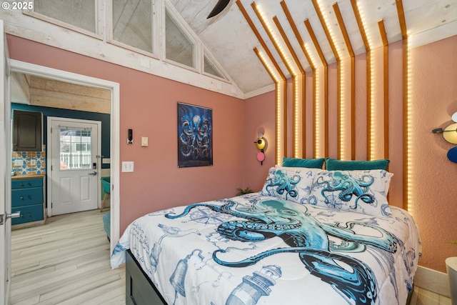 bedroom featuring light hardwood / wood-style floors, ornamental molding, and lofted ceiling