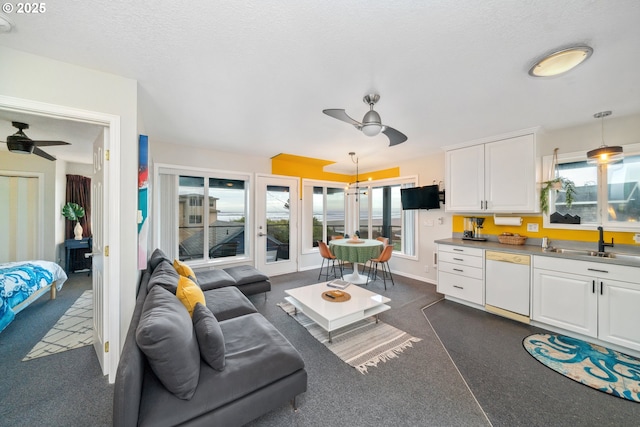 living room featuring sink, ceiling fan, and a textured ceiling