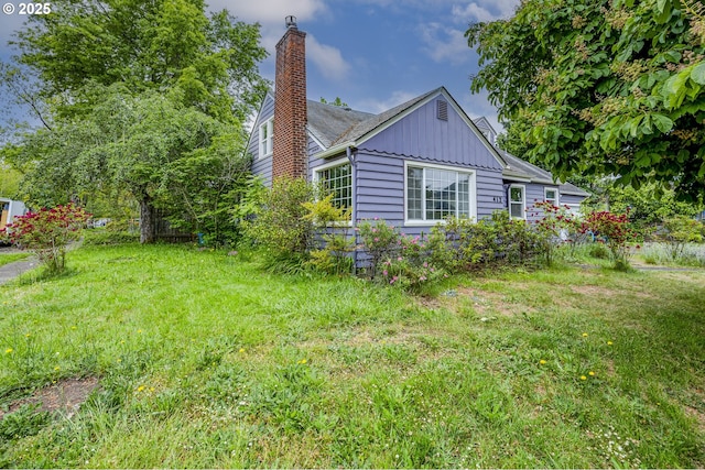 412 W 17th Ave, Eugene, OR 97401 - view of side of property with board and batten siding, a chimney, and a lawn
