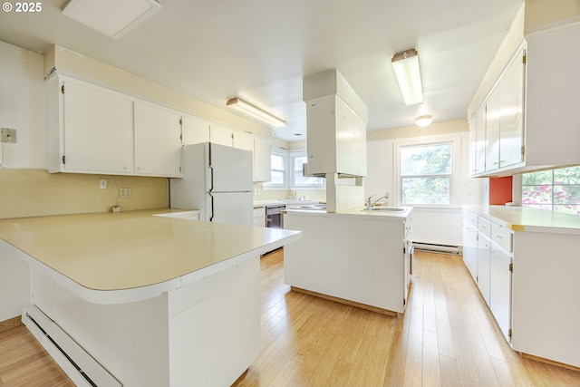 412 W 17th Ave, Eugene, OR 97401 - kitchen with a baseboard heating unit, a peninsula, a baseboard radiator, freestanding refrigerator, and a sink