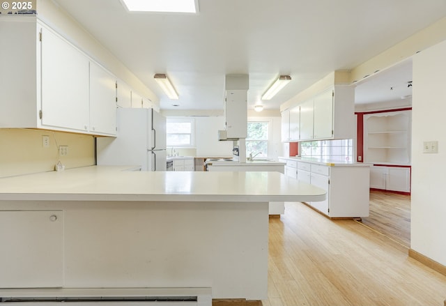412 W 17th Ave, Eugene, OR 97401 - kitchen with freestanding refrigerator, a peninsula, light countertops, and light wood-type flooring
