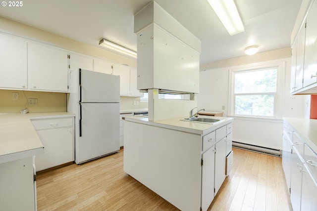412 W 17th Ave, Eugene, OR 97401 - kitchen featuring freestanding refrigerator, a sink, a baseboard radiator, and light wood-type flooring