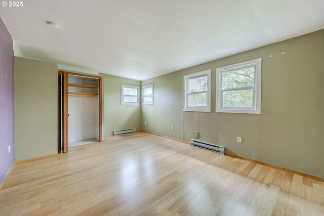 412 W 17th Ave, Eugene, OR 97401 - unfurnished bedroom with baseboard heating, light wood finished floors, and a closet