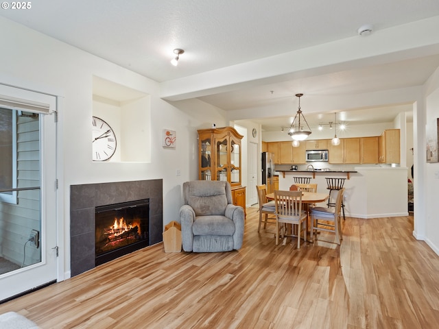 635 NW Lost Springs Ter Unit 104, Portland, OR 97229 - dining room featuring light wood finished floors and a tile fireplace