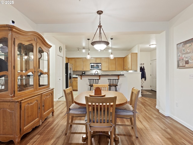 dining room with light wood-style floors and baseboards