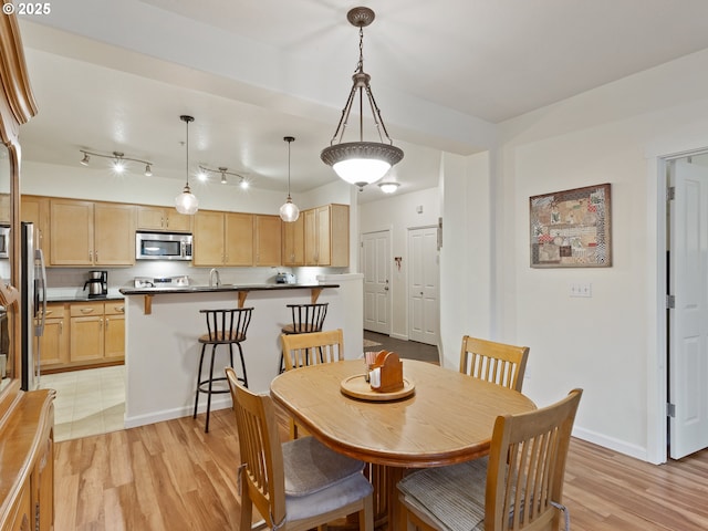 dining room featuring light wood finished floors and baseboards