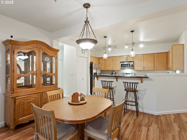 635 NW Lost Springs Ter Unit 104, Portland, OR 97229 - dining area with light wood-style flooring and baseboards