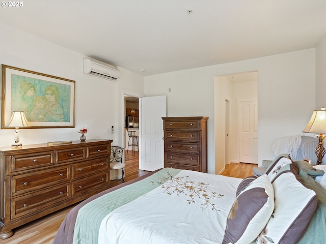 635 NW Lost Springs Ter Unit 104, Portland, OR 97229 - bedroom featuring an AC wall unit and light wood-style floors