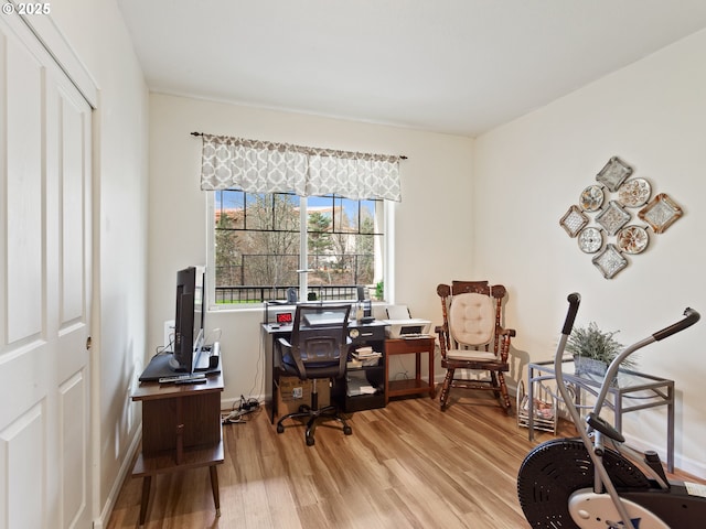 office space with baseboards and light wood-style floors