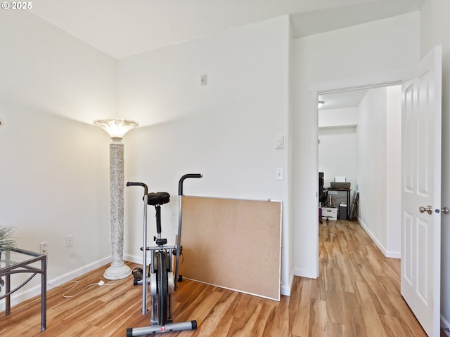 corridor featuring wood finished floors and baseboards