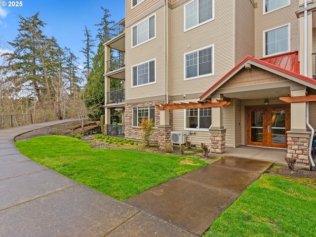 635 NW Lost Springs Ter Unit 104, Portland, OR 97229 - view of front of house featuring a cooling unit, a front lawn, french doors, and stone siding