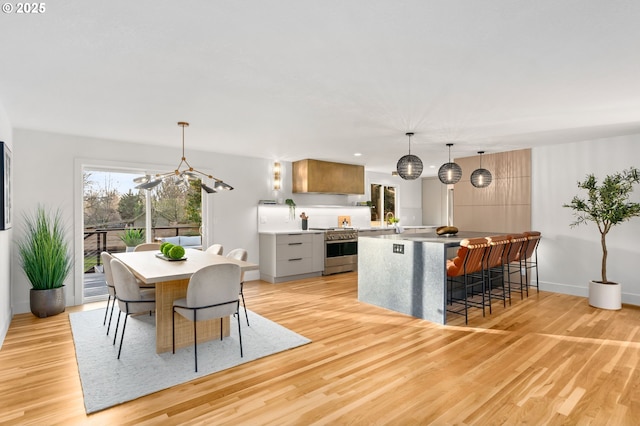 dining space featuring light wood-type flooring and an inviting chandelier