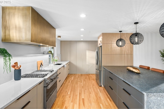 kitchen featuring sink, decorative light fixtures, light hardwood / wood-style floors, gray cabinetry, and appliances with stainless steel finishes