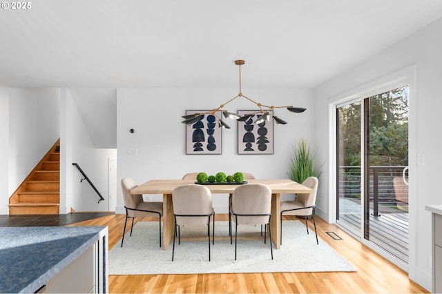 dining area with an inviting chandelier and light hardwood / wood-style floors