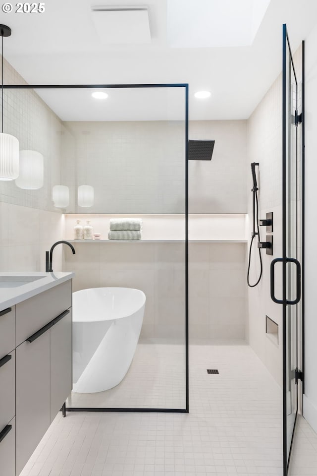 bathroom with vanity, tile patterned flooring, and plus walk in shower