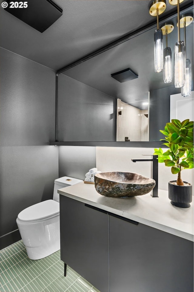 bathroom with toilet, vanity, and tile patterned floors