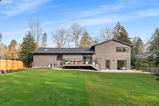 back of house featuring a lawn, a deck, and a patio area